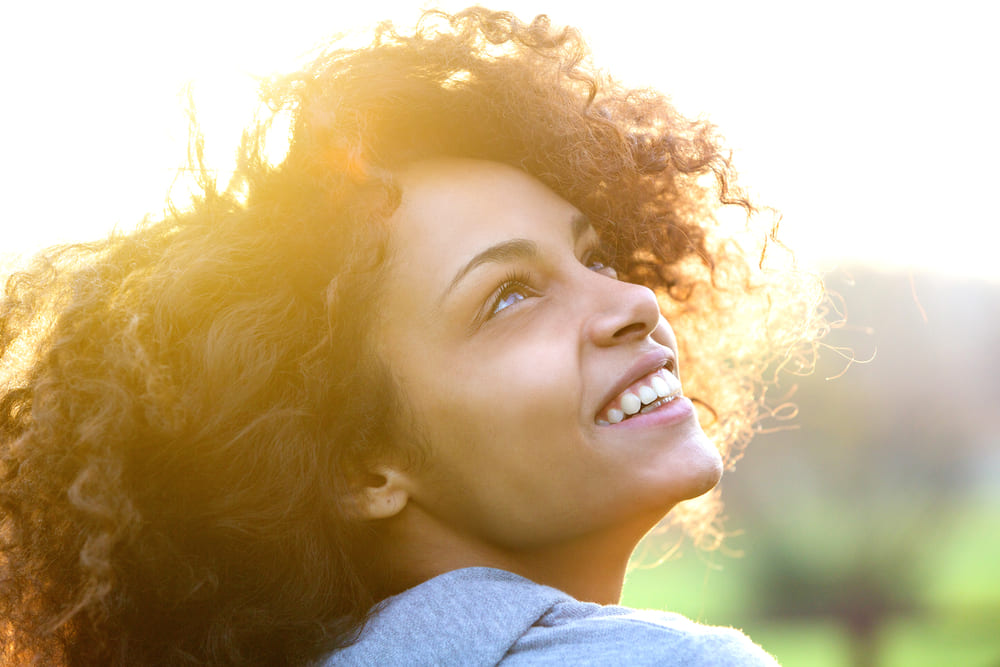 Close up portrait of a beautiful young african american woman smiling and looking up