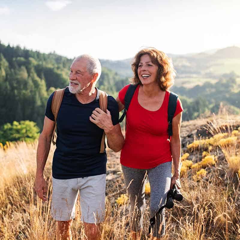 Portrait of Elderly Couple Hiking Mountains and Smiling