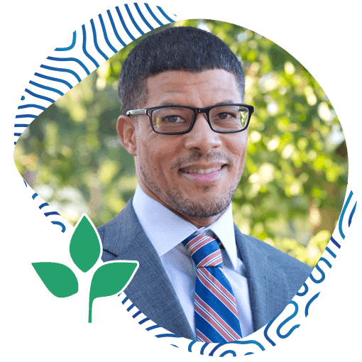 Portrait of Afro-American Man Wearing a Suit with a Tie and Glasses with a Natural Background. Ayo