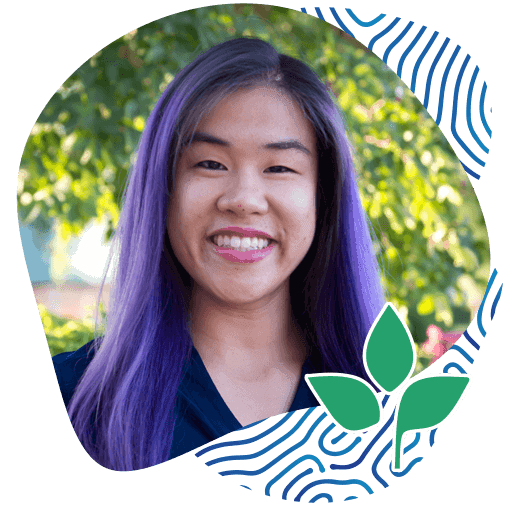 Portrait of Smiling Asian Lady Wearing a Blue Shirt with a Natural Background. Karolyn