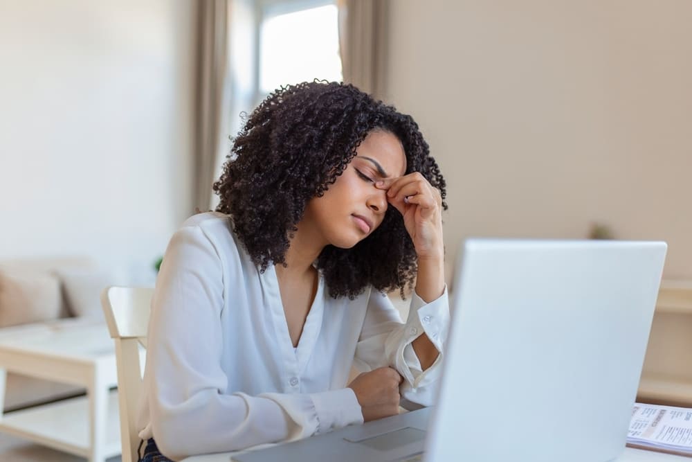 Exhausted businesswoman having a headache in home office.